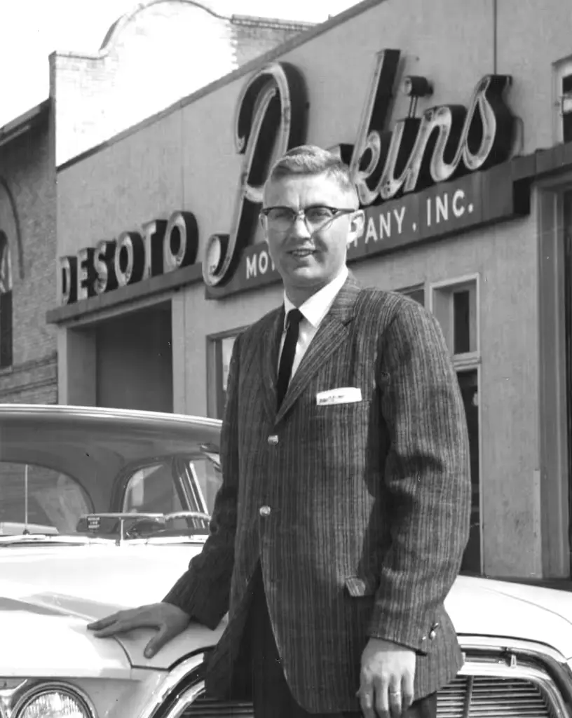 Guy in glasses by car.